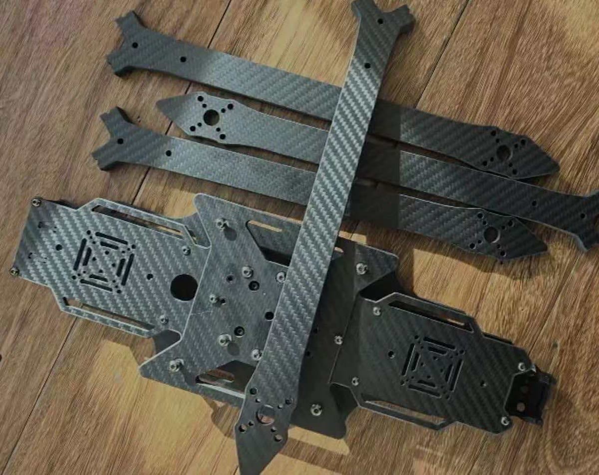 CNC-machined carbon fiber sheet components arranged with a partially assembled frame