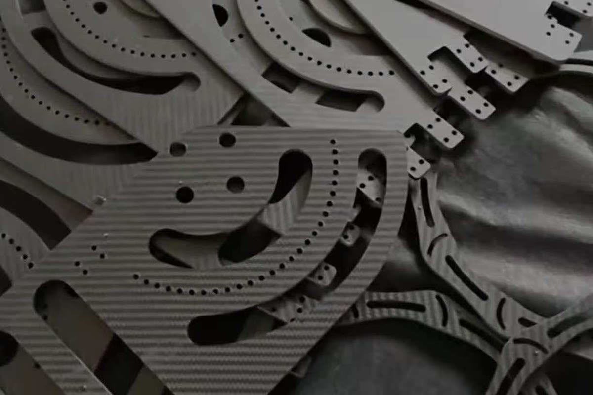 Assortment of CNC-machined carbon fiber sheet parts with contoured profiles, holes and slots